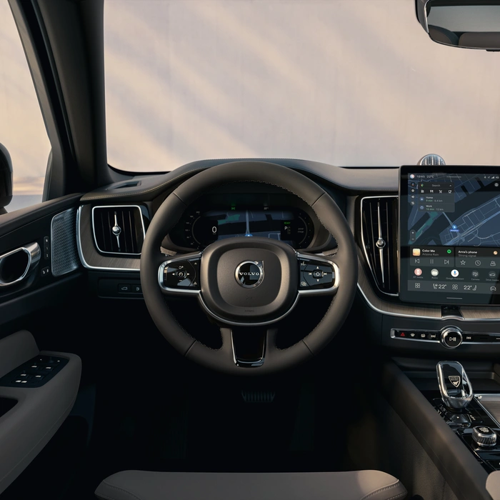 Vue intérieure d’un Volvo XC60 avec volant, tableau de bord et système d’infodivertissement