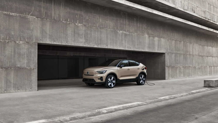 Volvo EC40 beige en charge devant un bâtiment moderne en béton au design minimaliste